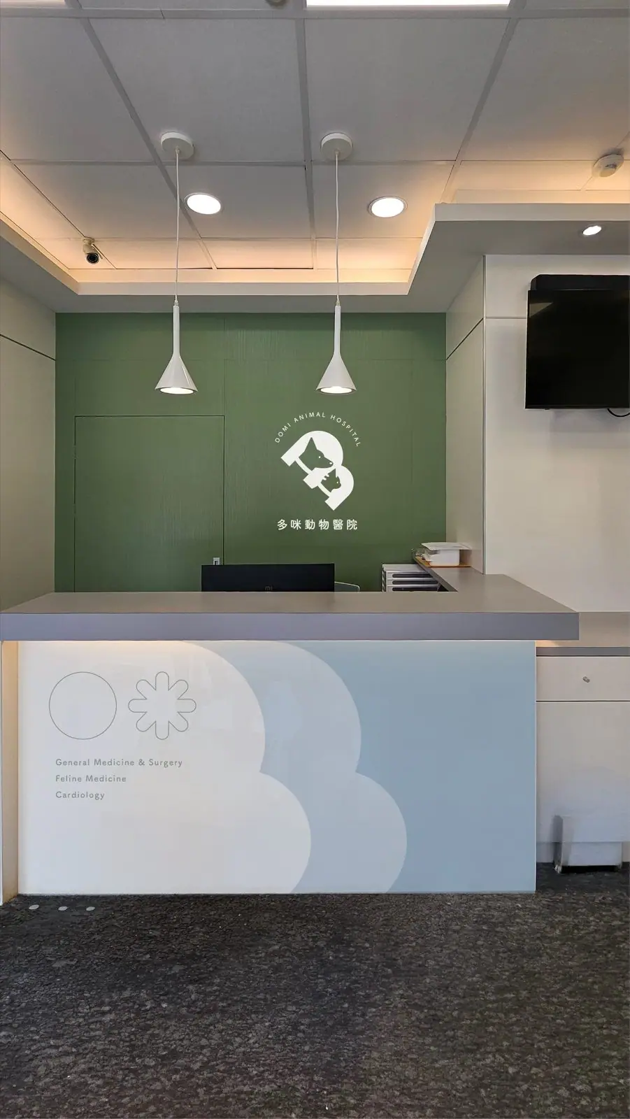 多咪動物醫院櫃檯背牆識別設計，森林綠牆面搭配白色品牌標誌