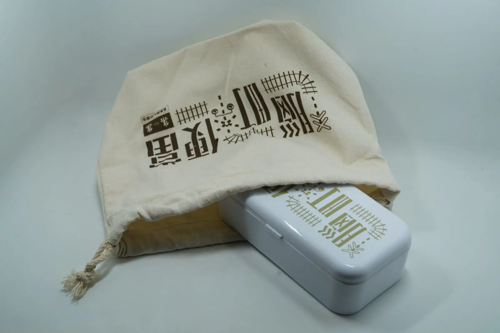 帆布提袋「腦町便當」標準字特寫,枕木與平交道圖騰
