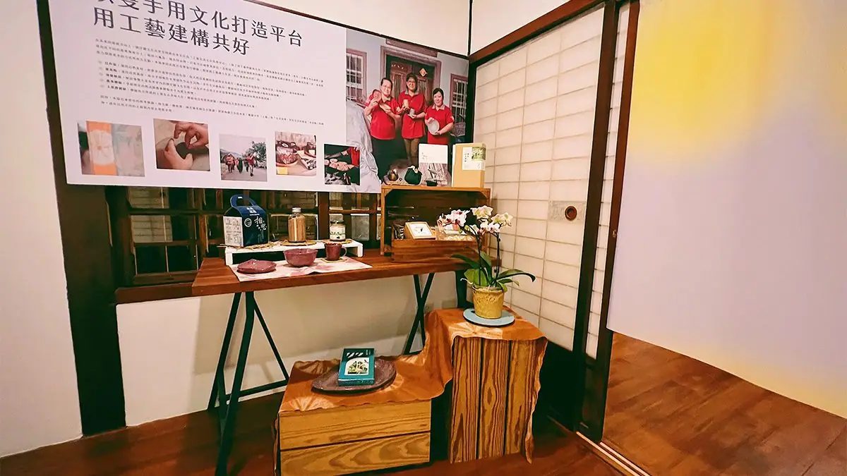 寶來人文協會三位工藝師手持自製陶器合影，身穿檨仔腳品牌制服