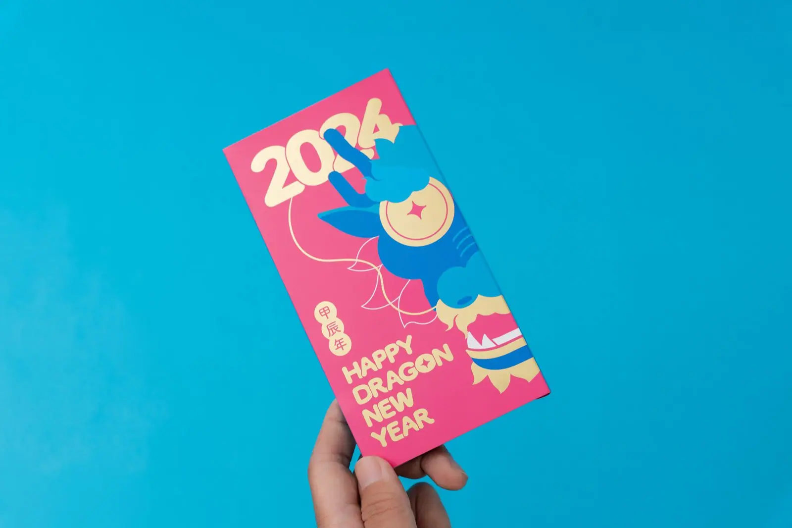 Hand holding the Fortune Dragon red packet, showing the gold foil lettering and paper texture