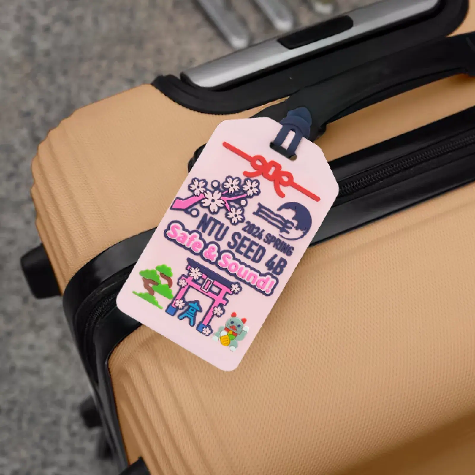NTU E-Force graduation trip commemorative luggage tag shown attached to a suitcase in use